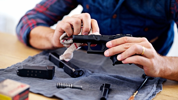 a man cleaning a handgun