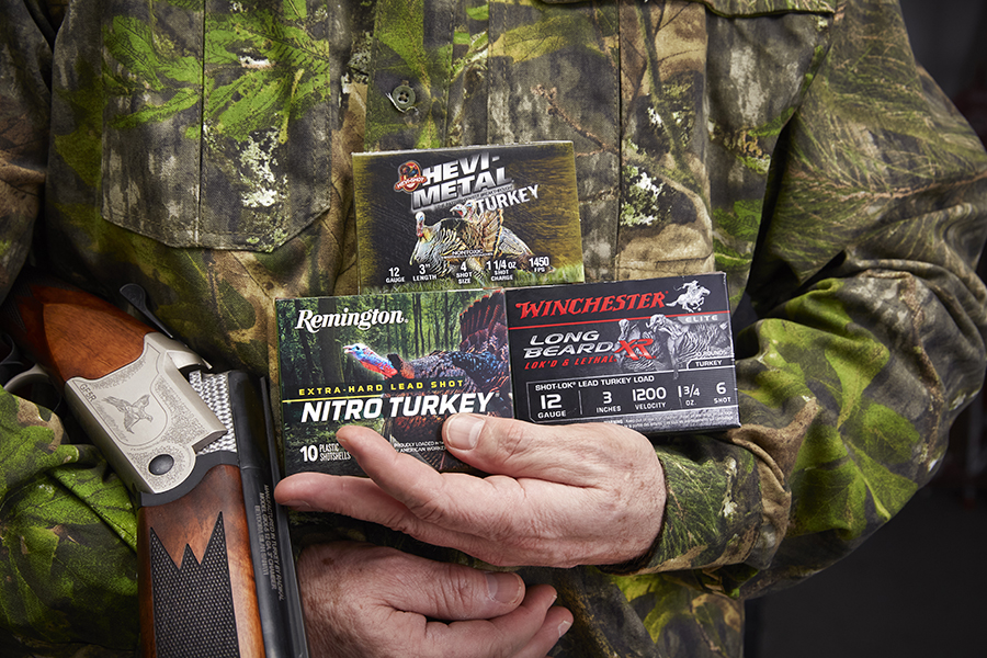 hunter in camouflage holding boxes of ammunition